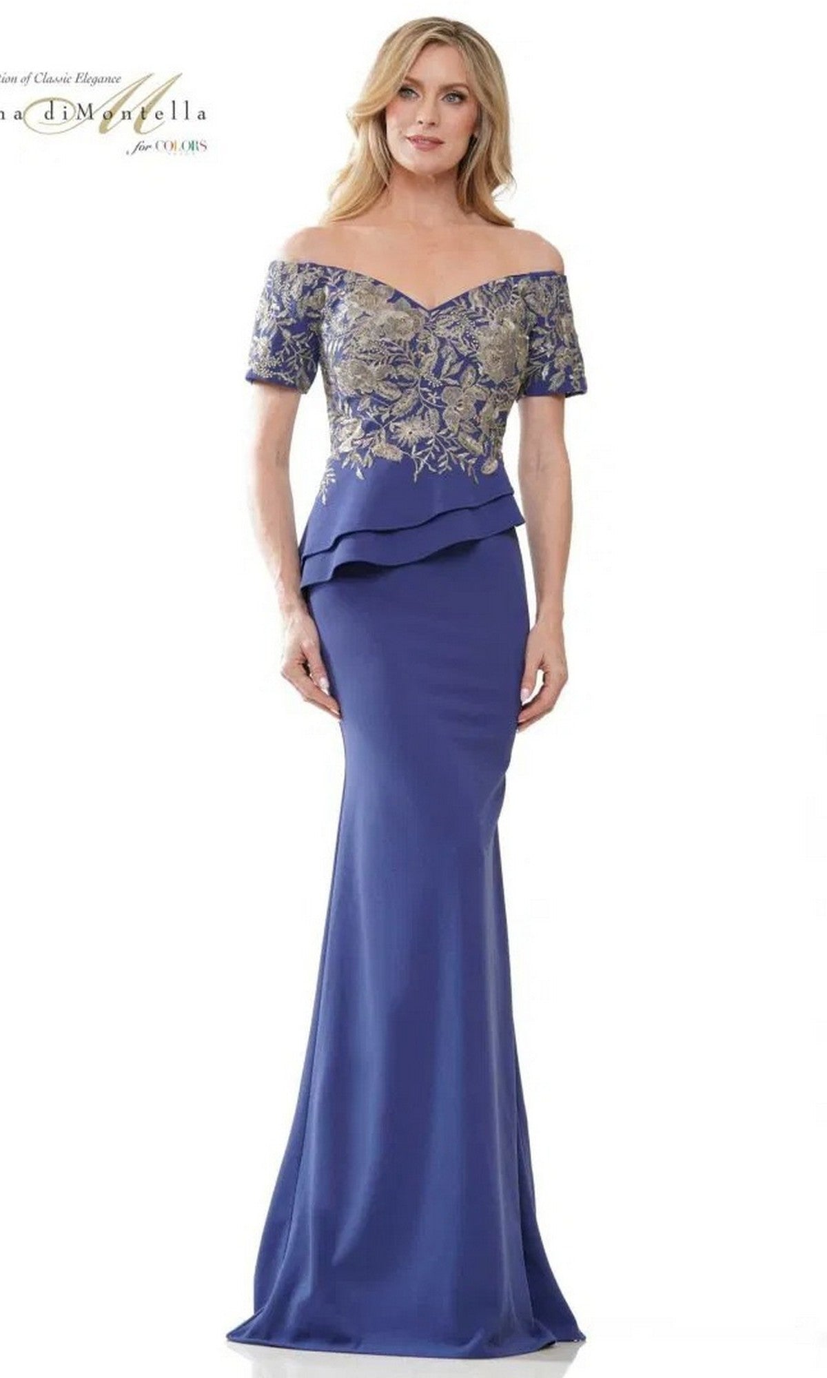 A woman wears the Long Formal Dress: Rina Di Montella RD2918 in Blue Iris, featuring an off-shoulder floor-length design with gold floral embroidery on the bodice and a peplum waist detail.
